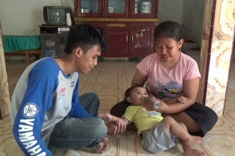 Café-amante de la base: en Indonesia, una madre le da a un bebé de un año de edad café en lugar de leche
