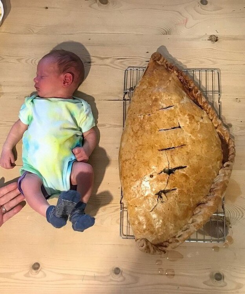 Feliz padre en honor del nacimiento de su hijo al horno una torta del tamaño de un niño