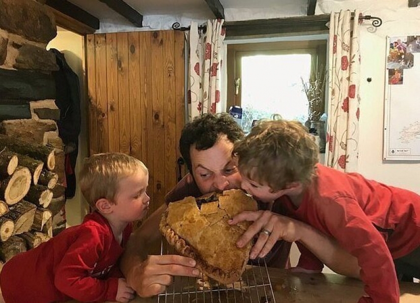 Feliz padre en honor del nacimiento de su hijo al horno una torta del tamaño de un niño