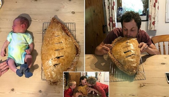 Feliz padre en honor del nacimiento de su hijo al horno una torta del tamaño de un niño