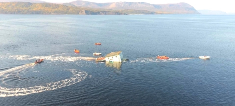 A couple from Canada transported their dream home by swimming across the lake on a homemade raft