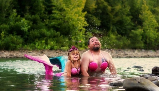 A photo shoot of a father with a little daughter in the image of mermaids conquered social networks