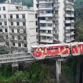 En China, un tren pasa a través de un edificio residencial