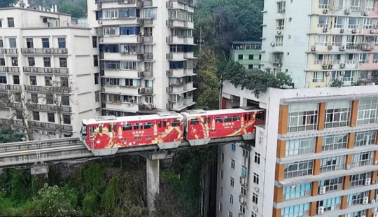 En China, un tren pasa a través de un edificio residencial