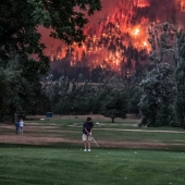 Golf during the plague: players on the background of a forest fire in the USA