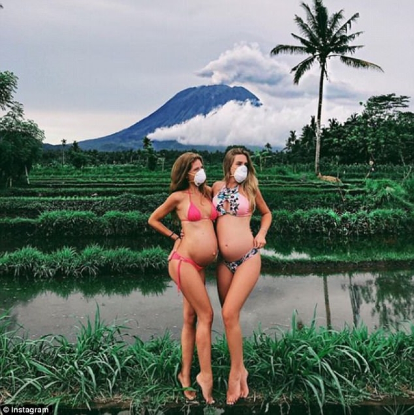 Mientras los residentes de Bali se alejan del volcán, los turistas son fotografiados con el telón de fondo de las emisiones de cenizas