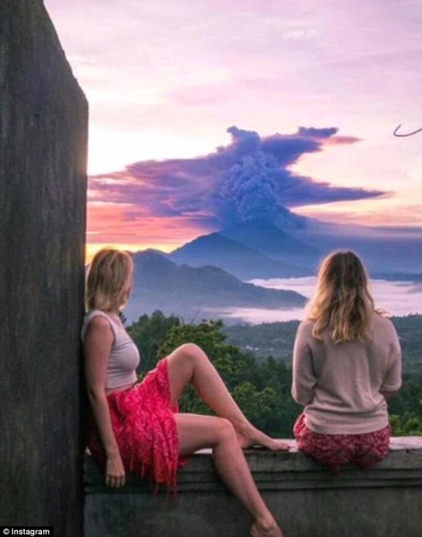 Mientras los residentes de Bali se alejan del volcán, los turistas son fotografiados con el telón de fondo de las emisiones de cenizas