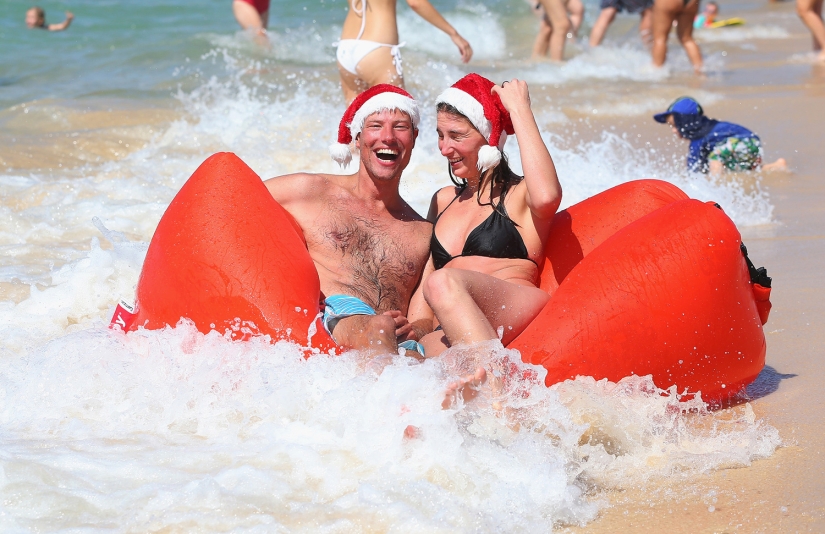 New Year and Christmas in Australian style: kangaroos instead of deer and Santa on a board with a paddle