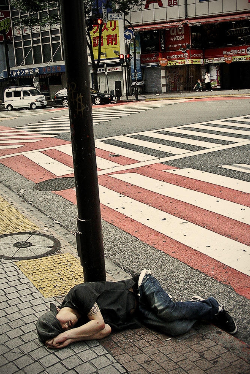 Residentes exhaustos de Tokio que duermen en la calle