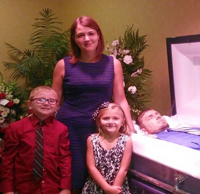 That's why this woman with children is smiling near her husband's coffin