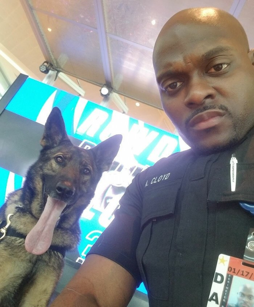 The girl noticed how a policeman at the airport takes a selfie with a service dog