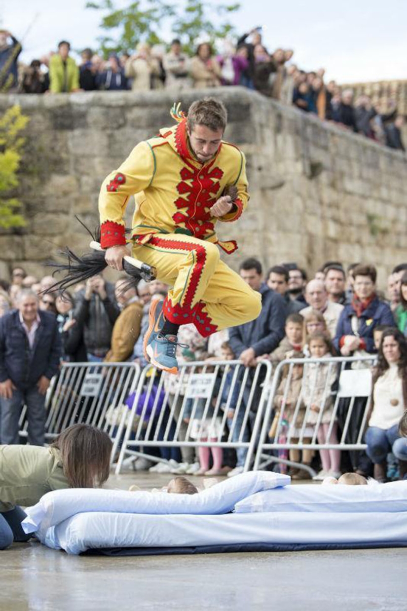 Why do Spaniards dress up as demons and jump over babies