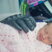 Newborn smiles in her sleep in the "embrace" of the gloves of the deceased father