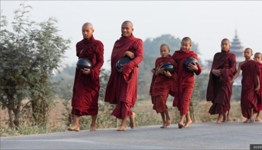 Salida del sol sobre campos de arroz y alimentación de monjes Salida del sol sobre campos de arroz y alimentación de monjes