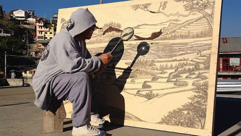 The artist draws with a magnifying glass and sunlight