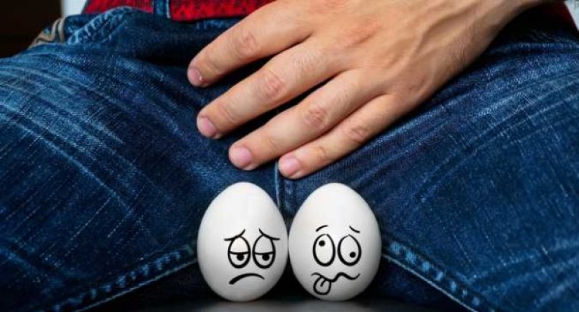 Why do men have one testicle lower than the other and is it normal