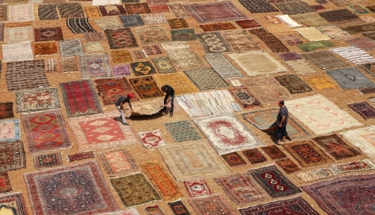 Why do the Turks lay out thousands of carpets in the fields?