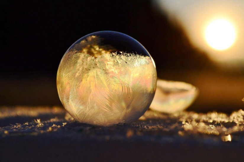 Bolas de cristal - una niña fotografía pompas de jabón en el frío