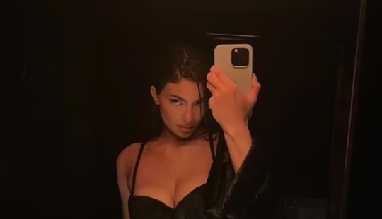 Kylie Jenner sorprende con un diminuto vestido sin tirantes y botas hasta la rodilla para la Semana de la Moda de París... después de compartir una foto candente con sujetador negro y ropa interior a juego.