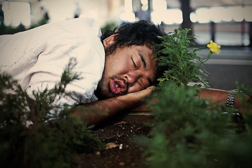 Residentes exhaustos de Tokio durmiendo en la calle
