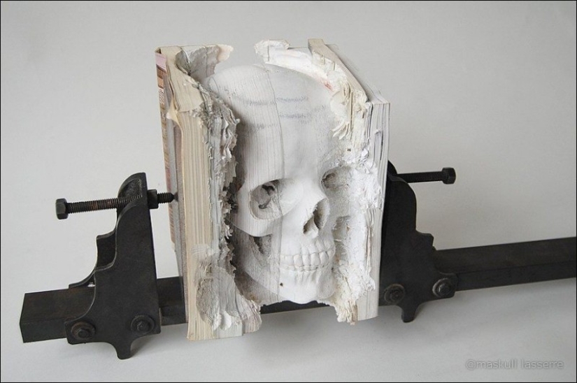 Step-by-step process of carving a skull from old books