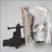 Step-by-step process of carving a skull from old books