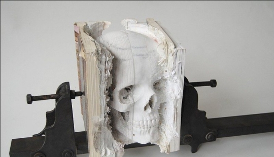 Step-by-step process of carving a skull from old books