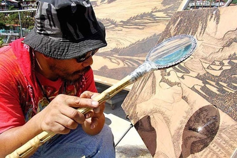 The artist draws with a magnifying glass and sunlight