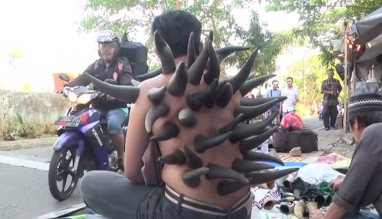 Why do street healers put horns on patients' backs in Indonesia