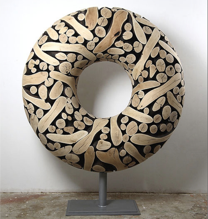 There is grass in the yard, firewood on the grass