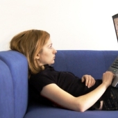 Why is it harmful to work at a laptop lying down